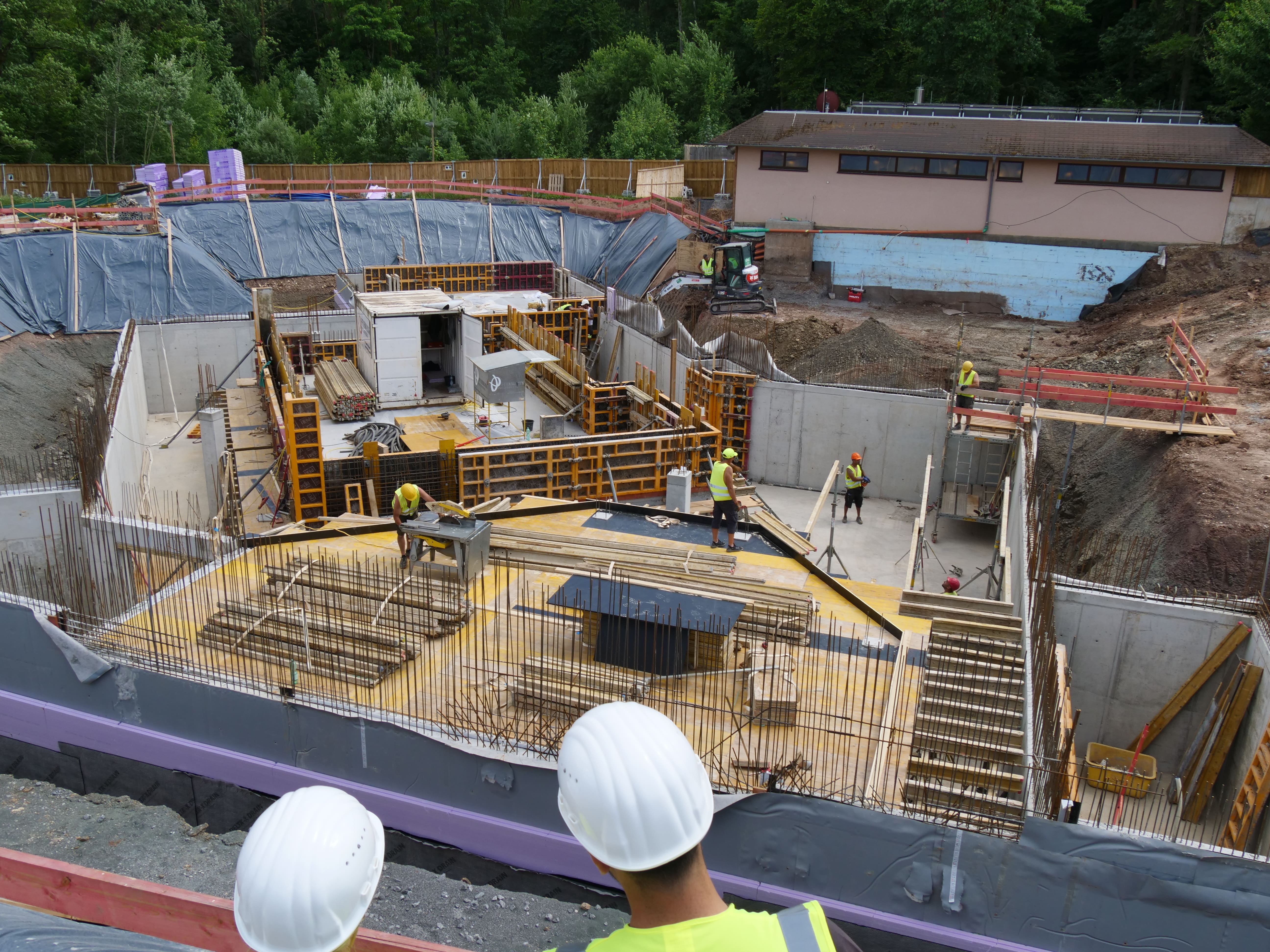 Baustelle mit Bauarbeitern, die gerade Wände betonieren