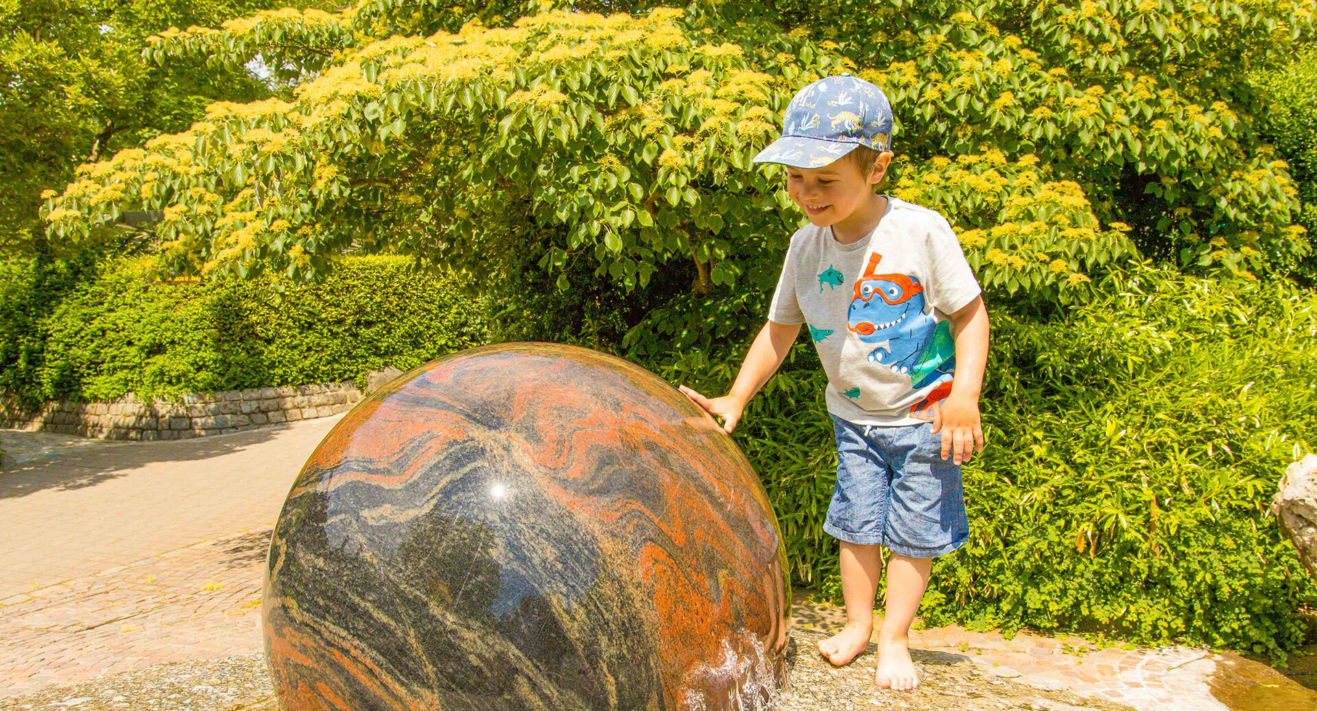 Kind mit Schwimmender Granitkugel