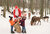 Weihnachtsmann mit Kindern und Rehen im Hintergrund